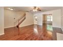Open-concept living room features hardwood floors, a staircase, and views into the dining room and kitchen at 307 Lee Miller Dr, Suwanee, GA 30024