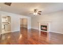 Spacious living room with hardwood floors, fireplace, and view into the dining room and kitchen at 307 Lee Miller Dr, Suwanee, GA 30024
