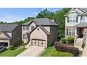 A suburban home with a two-car garage, green lawn, and manicured landscaping, showcasing classic curb appeal at 456 Crestmont Ln, Canton, GA 30114