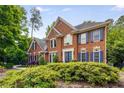 Charming brick home with blue shutters and a manicured front yard, providing a welcoming curb appeal at 710 Devon Hill Ct, Roswell, GA 30075