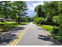 Residential street view with mature trees and well-maintained lawns leading to the property at 3443 Estes Dr, South Fulton, GA 30349