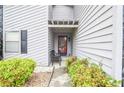 Inviting front porch entrance with a cozy chair, lush greenery, and stylish gray siding at 5697 Brooklyn Ln, Norcross, GA 30093