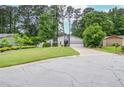 Charming single-Gathering home featuring a well-manicured front yard, mature trees, and attached two-car garage at 5697 Brooklyn Ln, Norcross, GA 30093