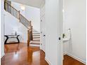 Bright entryway with hardwood floors, staircase with dark banister, white trim, and a powder room at 8360 Village School Dr, Cumming, GA 30041