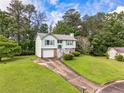 Charming home featuring a one-car garage, light-green siding, and a beautifully landscaped front yard at 2485 Shady Shoals Ct, Decatur, GA 30034