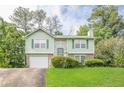 Charming two-story home with green siding, shutters, brick accents, garage and a well-maintained front yard at 2485 Shady Shoals Ct, Decatur, GA 30034