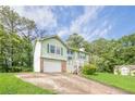 Charming two-story home with green siding, shutters, brick accents, garage and a well-maintained front yard at 2485 Shady Shoals Ct, Decatur, GA 30034