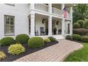 Inviting covered front porch with rocking chairs, decorative plants, and a charming brick walkway at 1042 Trailridge Pl, Atlanta, GA 30338