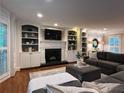 Cozy living room featuring a fireplace with white shelving and a comfortable, oversized sectional couch at 1042 Trailridge Pl, Atlanta, GA 30338