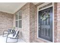 Inviting front porch with chairs, decorative wreath, and stylish brickwork create a warm welcome at 6179 Ashbranch Dr, Acworth, GA 30101
