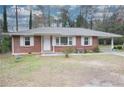 Inviting brick home featuring a classic design, covered carport, and neat front yard at 1693 Montreal Rd, Tucker, GA 30084