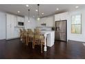 Spacious kitchen featuring a large island with seating, stainless steel appliances, and modern lighting fixtures at 2006 Towneship Trl, Roswell, GA 30075