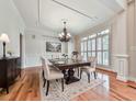 Elegant dining room with hardwood floors, chandelier, and large windows with plantation shutters at 414 Candler Trl, Canton, GA 30115
