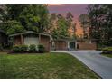 Charming brick home featuring a well-manicured lawn and a long driveway in a serene, wooded setting at 4469 Huntington Cir, Atlanta, GA 30338