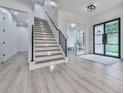 Elegant foyer with modern staircase, black-framed door, and light hardwood flooring at 106 Belmont Dr, Canton, GA 30115