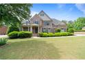 Stately brick home with a lush green lawn and a welcoming front entrance with columns at 1758 Rosehedge Nw Way, Kennesaw, GA 30152