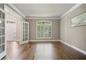 Living room with hardwood floors, French doors, beautiful arched windows, and neutral wall colors at 1758 Rosehedge Nw Way, Kennesaw, GA 30152
