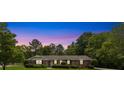 Brick home illuminated at twilight showing blue shutters and manicured landscaping at 2785 Fontainebleau Dr, Dunwoody, GA 30360