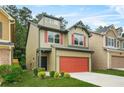 This two-story home boasts a red garage door, green trim, and is set on a well-manicured lawn at 6571 Splitpine Ct, Atlanta, GA 30349