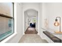 Hallway with arched doorways, stone floors and a modern table lamp, leading to the living spaces at 6571 Splitpine Ct, Atlanta, GA 30349