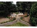 An outdoor living space features a stone patio with fire pit and seating, surrounded by mature trees and landscaping at 3019 Haverford Se Ln, Marietta, GA 30067