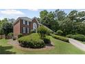 Landscaped lawn with mature shrubbery highlighting this 2-story brick home at 530 Veranda Ct, Alpharetta, GA 30009