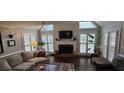 Cozy living room with fireplace, plantation shutters, and ample natural light at 530 Veranda Ct, Alpharetta, GA 30009