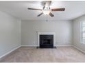 A cozy living room with plush carpeting, a ceiling fan, and a classic fireplace at 3075 Oakvale Hts, Decatur, GA 30034