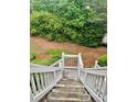 View down outdoor wooden steps surrounded by lush greenery and landscaping at 104 Abingdon Way, Atlanta, GA 30328
