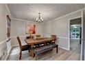 Traditional dining room featuring a rustic wood table set beneath an elegant chandelier at 1486 Maple Ridge Dr, Suwanee, GA 30024