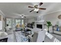 Bright living room with fireplace, gray carpet, neutral paint, ceiling fans, and views to the backyard at 1486 Maple Ridge Dr, Suwanee, GA 30024
