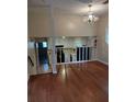 Open-concept living space with hardwood floors, a view of the kitchen, and stylish chandelier at 604 Pepperwood Ln, Stone Mountain, GA 30087
