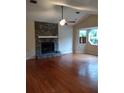 Spacious living room featuring a stone fireplace, ceiling fan, and large windows for natural light at 604 Pepperwood Ln, Stone Mountain, GA 30087