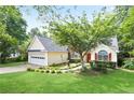 Inviting single-story home with a manicured lawn, red door, and two car garage at 174 Saint Georges Ct, Suwanee, GA 30024