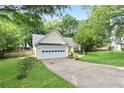 Street view of a single-story home with a two car garage and manicured lawn at 174 Saint Georges Ct, Suwanee, GA 30024
