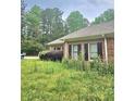 Side view of brick home showcasing manicured lawn and mature landscaping at 4855 West Price Rd, Sugar Hill, GA 30518