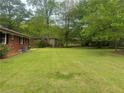 Spacious backyard view showing lush green grass, mature trees, and a partial view of the home's exterior at 3731 Wisteria Se Ln, Smyrna, GA 30082