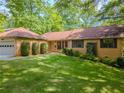 Charming single-story brick home with a manicured lawn and lush landscaping at 3809 Cotswold Sw Dr, Lilburn, GA 30047