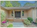Inviting covered front entry with a double door, brick facade, and well-maintained landscaping at 3809 Cotswold Sw Dr, Lilburn, GA 30047