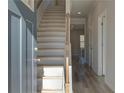 Inviting entryway featuring hardwood floors, a staircase with wood banister, and light gray walls at 124 Dalston Cv, Stockbridge, GA 30281