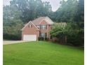 Well-maintained two-story brick home with a large front lawn and attached two car garage at 1558 Ember Oaks Cir, Powder Springs, GA 30127