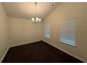 Bright dining room with modern chandelier, neutral walls, and dark wood-look flooring at 363 Chadwick, Stockbridge, GA 30281