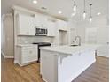 Bright, open-concept kitchen with white cabinets, island, stainless steel appliances, and modern fixtures at 162 Bluffington Way, Marietta, GA 30066