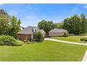 View of the lovely brick home with lush green lawn, attractive landscaping, and long driveway at 5791 Epping Ct, Douglasville, GA 30135