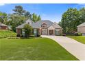 Beautiful brick home featuring a manicured lawn, lush landscaping, and a welcoming driveway at 5791 Epping Ct, Douglasville, GA 30135