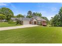 Stunning brick home with attached garage, long driveway, landscaped lawn, and mature trees at 5791 Epping Ct, Douglasville, GA 30135