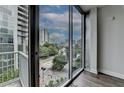Balcony view overlooking the city with lush greenery, high-rise buildings, and a bright sky at 950 W Peachtree Nw St # 911, Atlanta, GA 30309