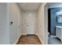 Inviting hallway with hardwood floors, leading to a bathroom with stylish blue accent wall at 950 W Peachtree Nw St # 911, Atlanta, GA 30309