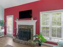 A stone fireplace with a white mantel, TV, and large windows creating a warm atmosphere at 100 Sydney Smt, Villa Rica, GA 30180