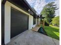 Close up of the home's garage and painted brickwork, accented by a wooden porch and lush green lawn at 2400 Glenrock Dr, Decatur, GA 30032